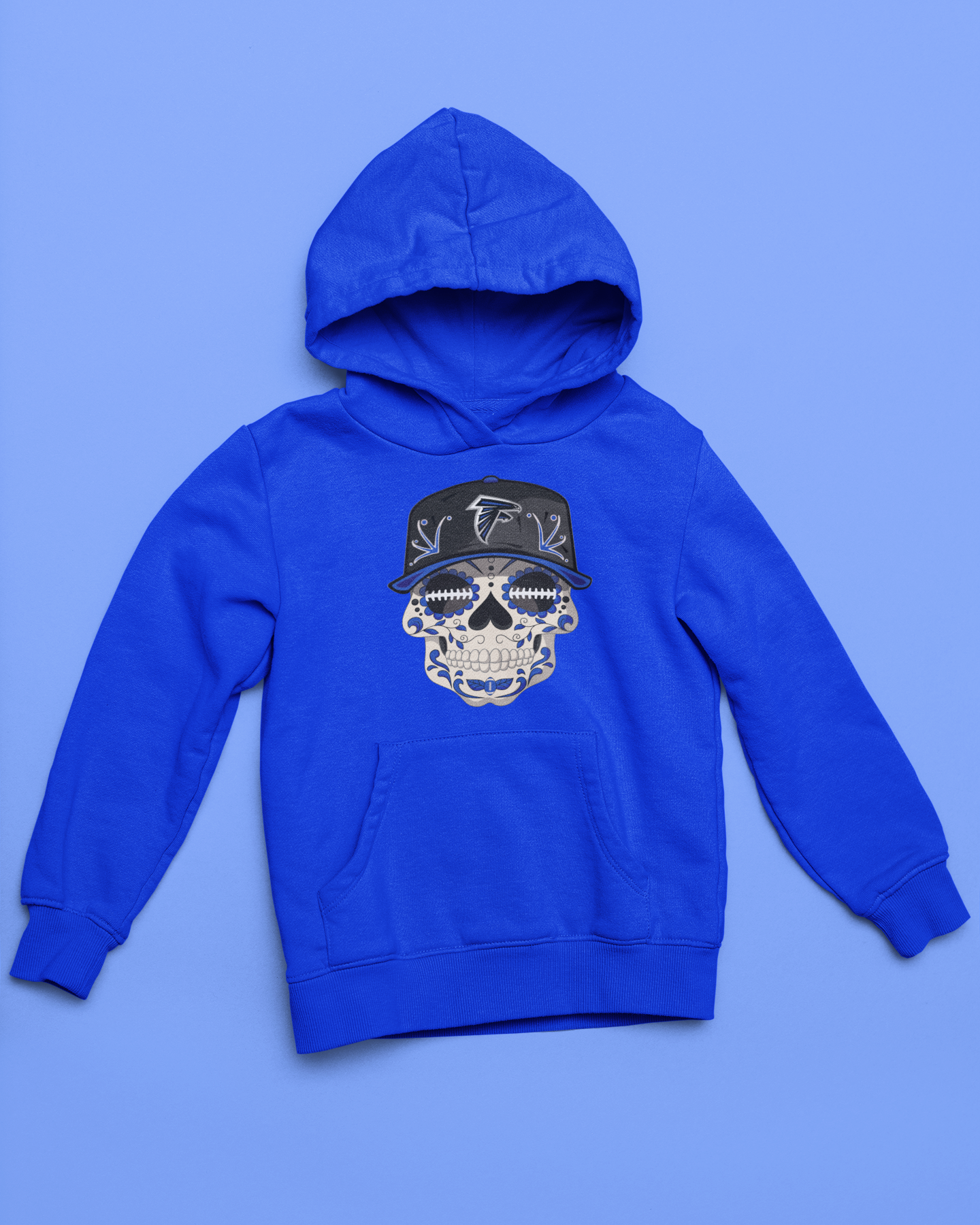 Royal blue youth unisex sponge fleece pullover hooded sweatshirt with Sharon Springs Falcons  "Sugar Skull" logo placed against a solid blue surface